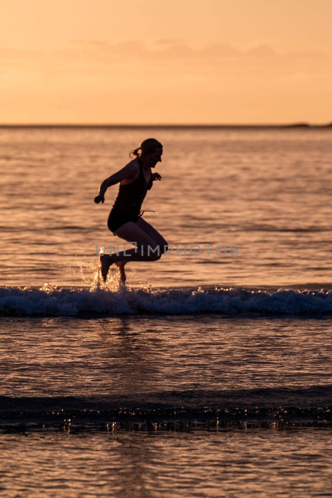 Silhouette of female swimmer going into the Atlantic ocean in Ireland.