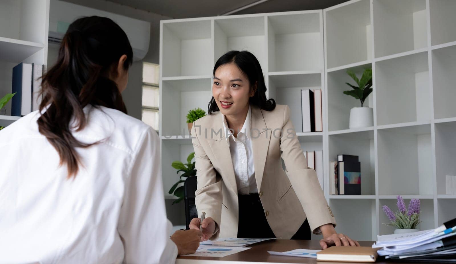 Team businesswomen discussing financial reports in office.