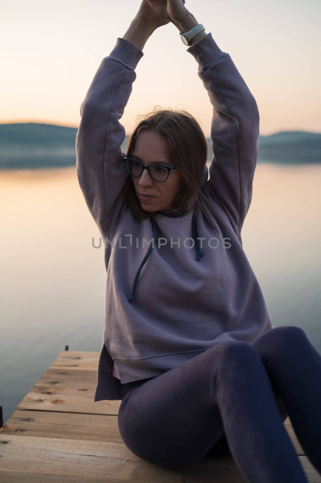 Woman sitting on the pier, closeup portrait, summer sunset