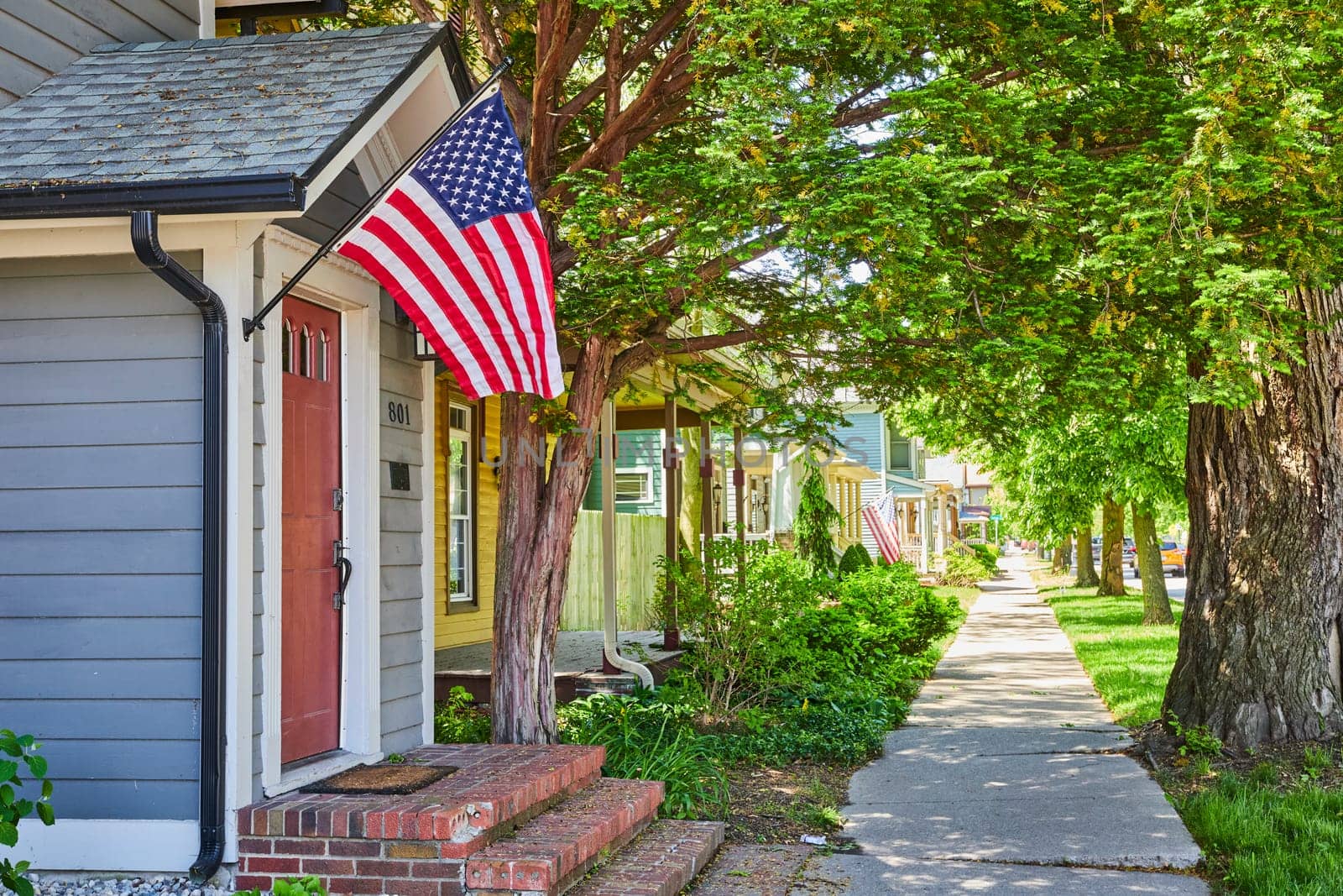 Patriotic American suburb with flags on houses in a serene, historic neighborhood in Fort Wayne, Indiana.