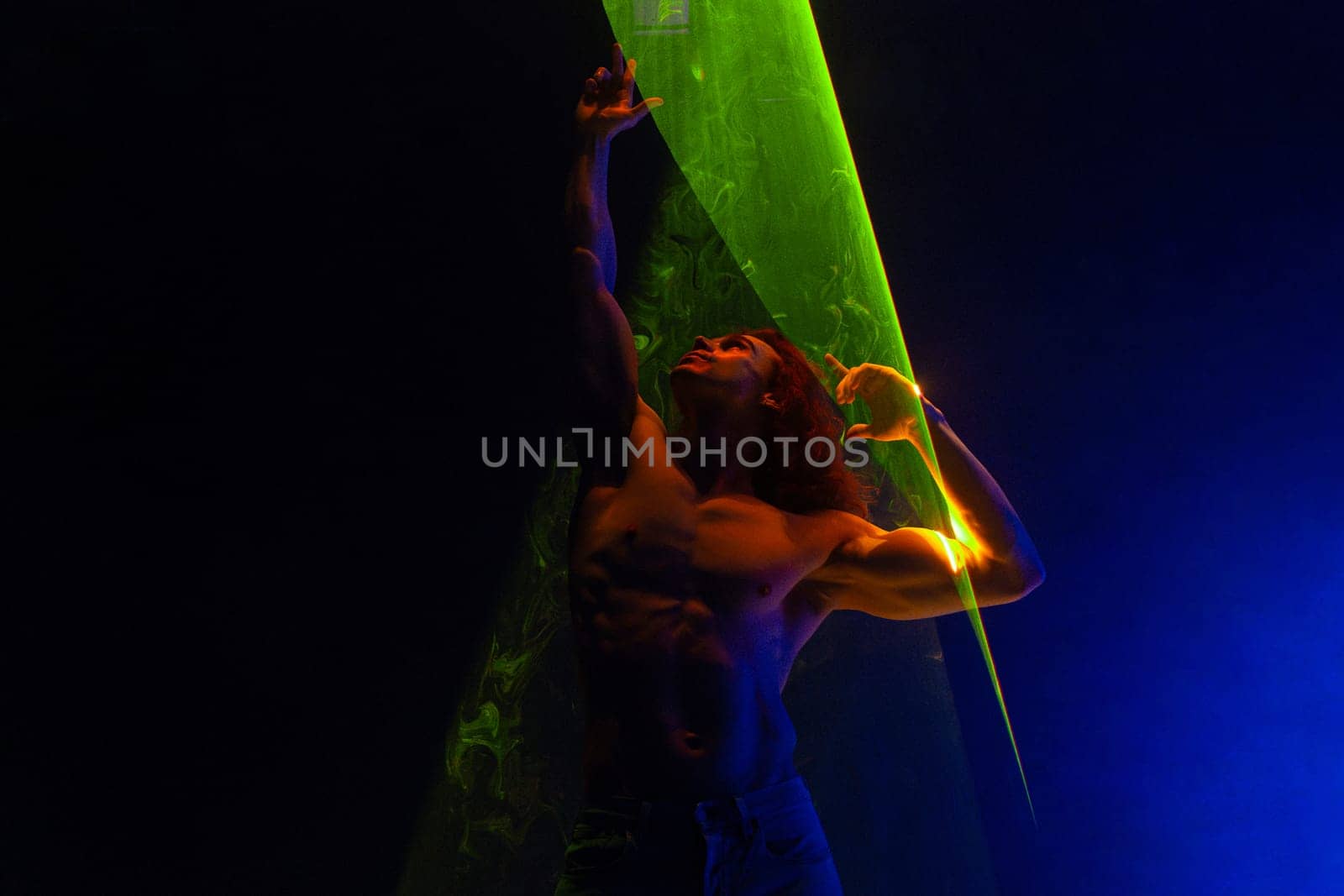 Sporty handsome muscular man portrait under colorful illumination, laser light by kristina_kokhanova
