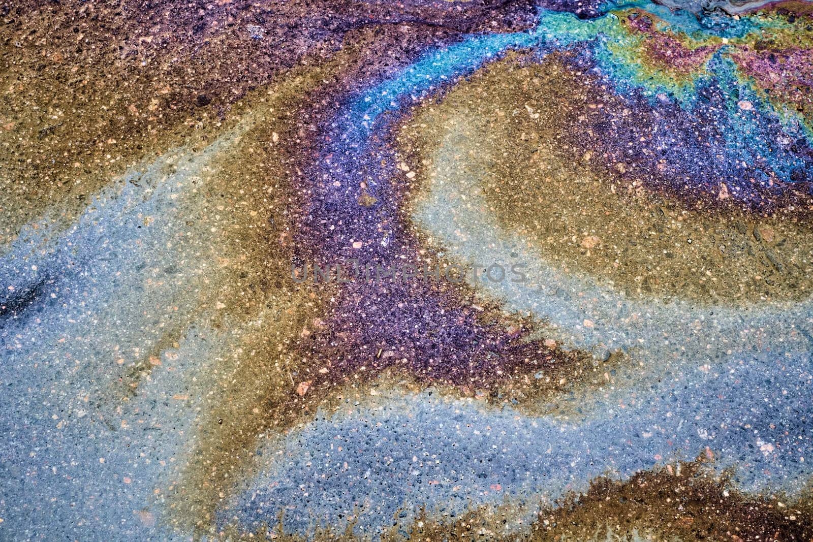 Texture of colorful petrol oil spill on wet pavement