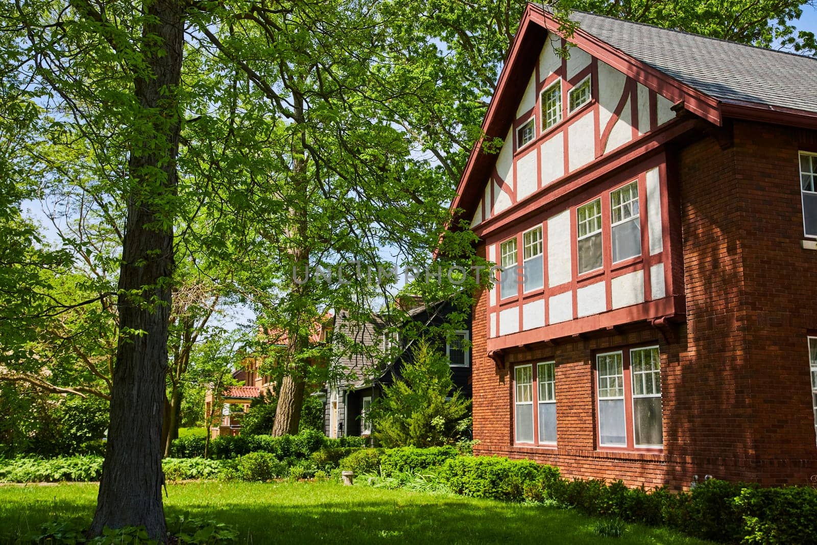 Charming Tudor-style home in South Wayne Historic District, Fort Wayne, enveloped by lush greenery.