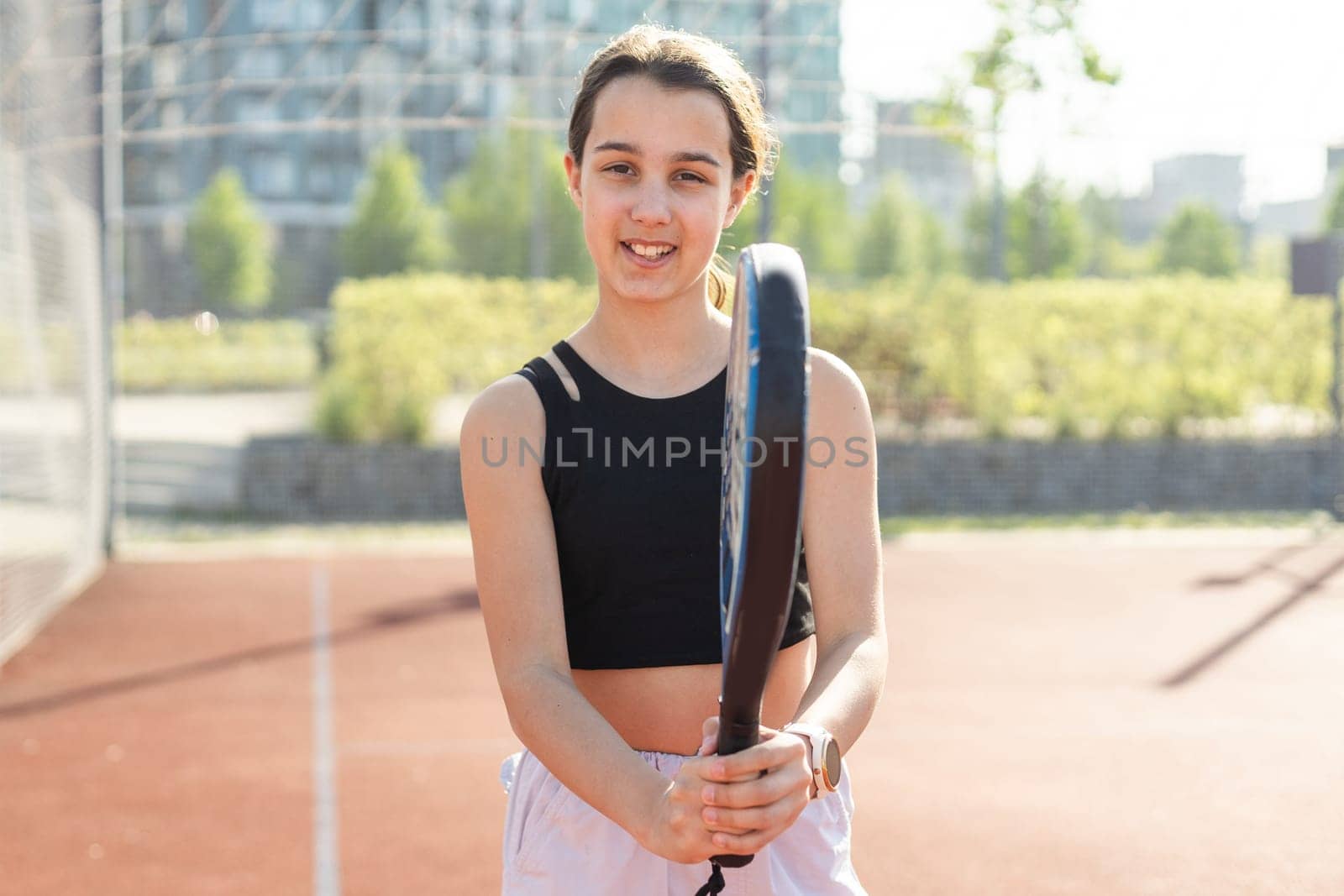 Padel tennis player with racket and ball in hands. Girl athlete with paddle racket on court outdoors. Sport concept. Download a high quality photo for the design of a sports app or web site. by Andelov13