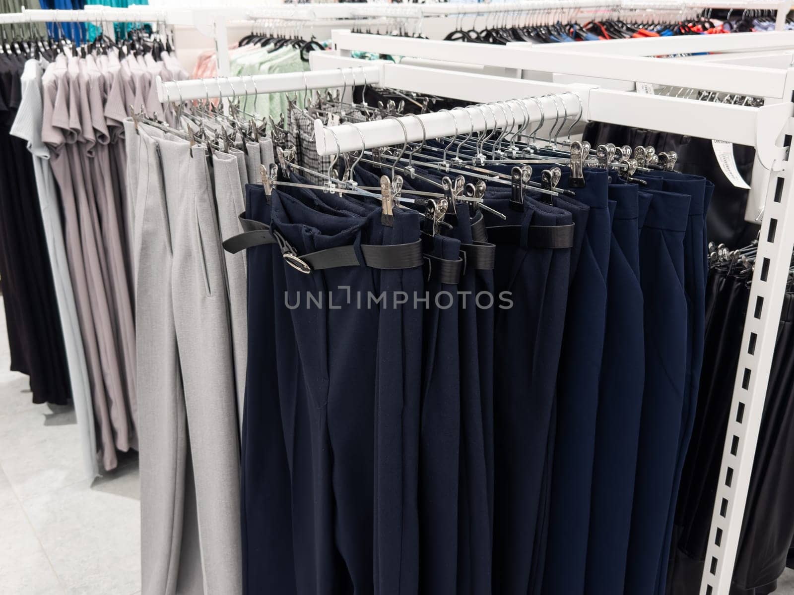 Row of hanged men Several different pants in a shop. Clothes store. by Andelov13