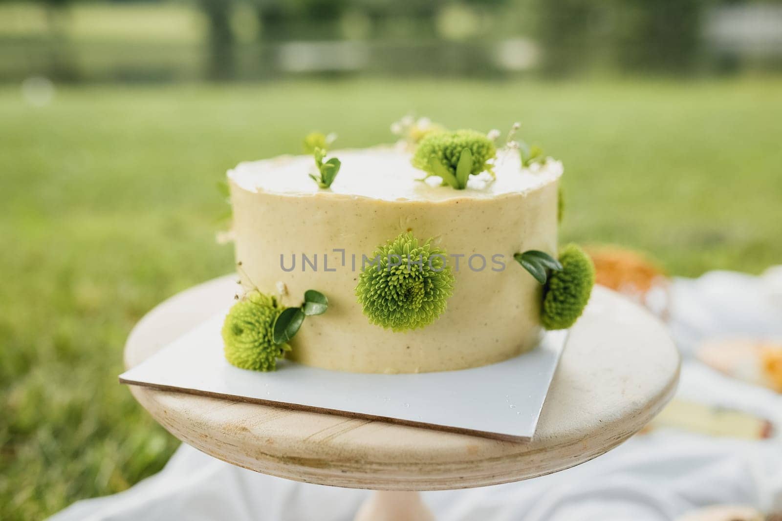 A luscious yellow cake adorned with vibrant green flowers on top, creating a beautiful and whimsical dessert centerpiece.