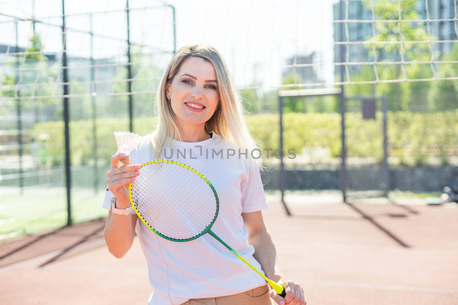 Beauty sport. Pretty young woman in fitness clothes. Slim body. Look at camera. Badminton exercise. Power wellness. Workout lifestyle. Training position. by Andelov13