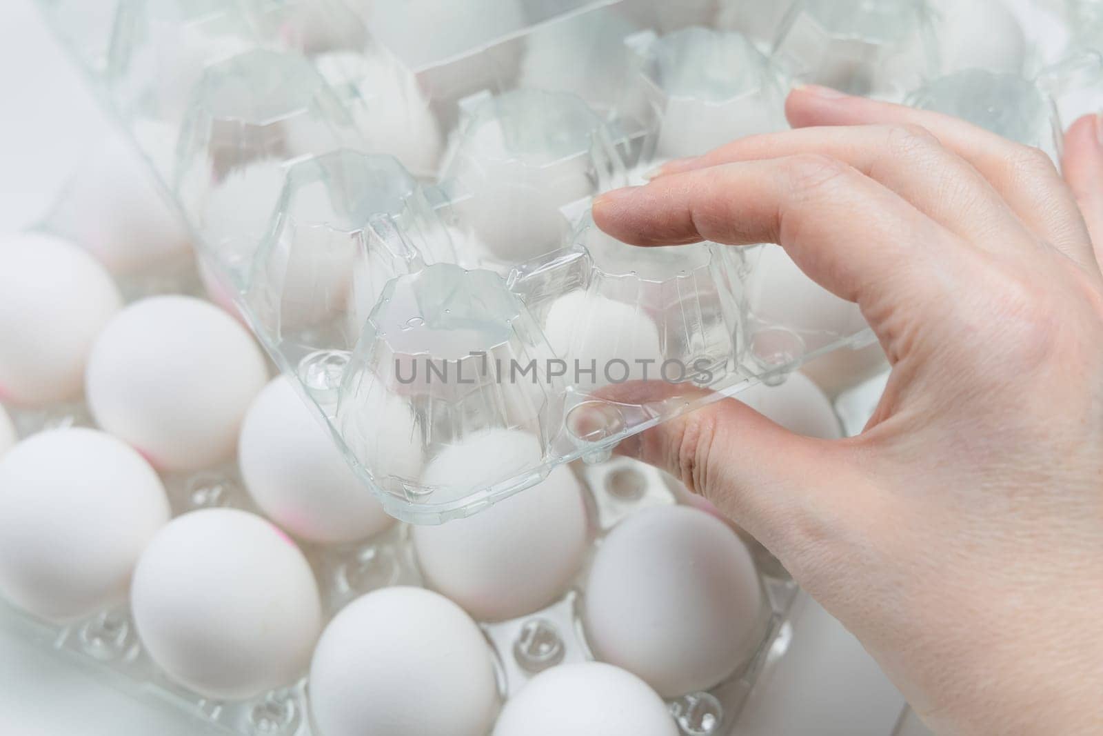 Raw white chicken eggs in tray on white background. Organic food from nature.