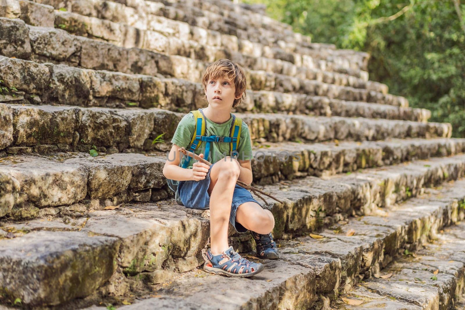 Boy tourist at Coba, Mexico. Ancient mayan city in Mexico. Coba is an archaeological area and a famous landmark of Yucatan Peninsula. Cloudy sky over a pyramid in Mexico.