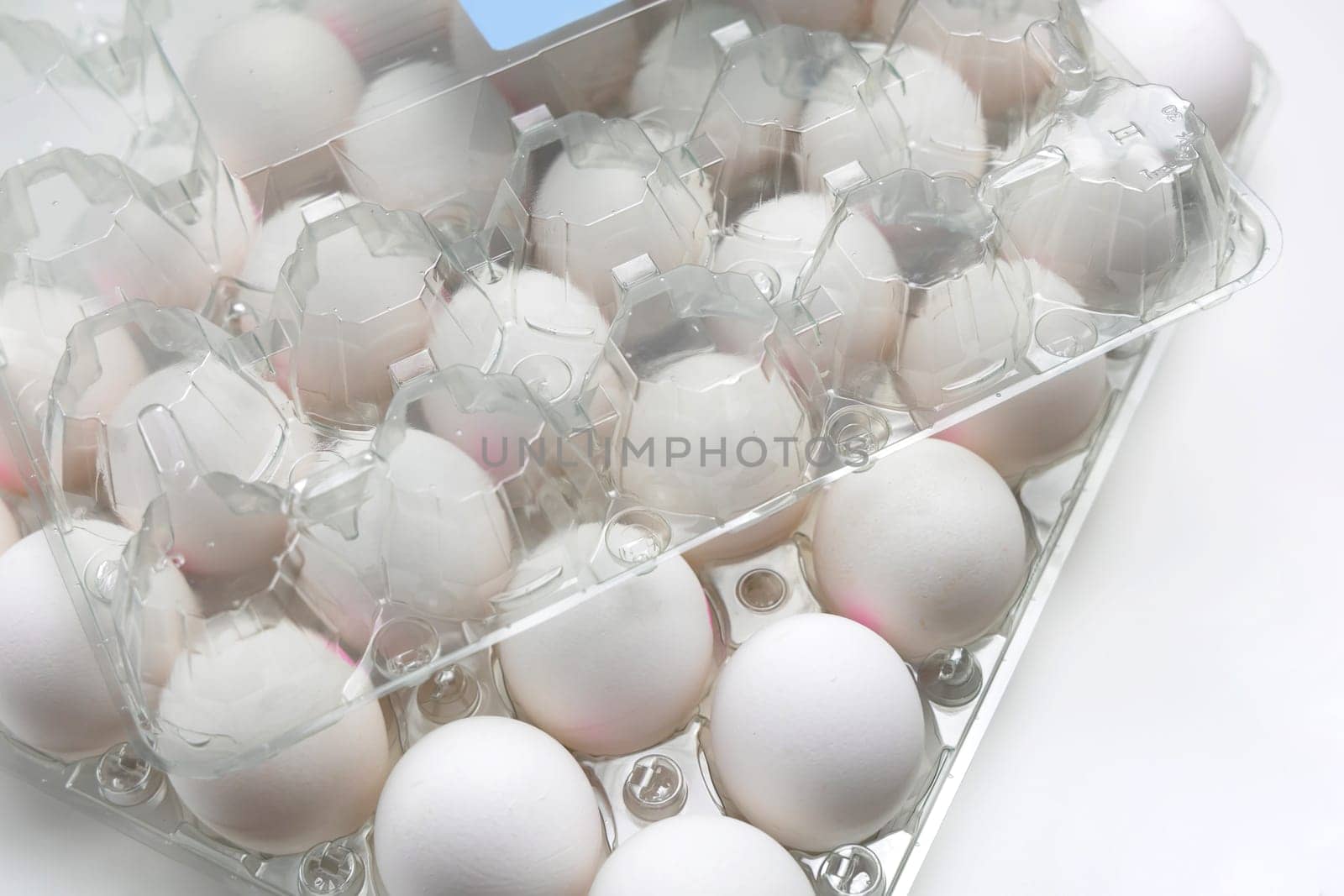 Raw white chicken eggs in tray on white background. Organic food from nature.