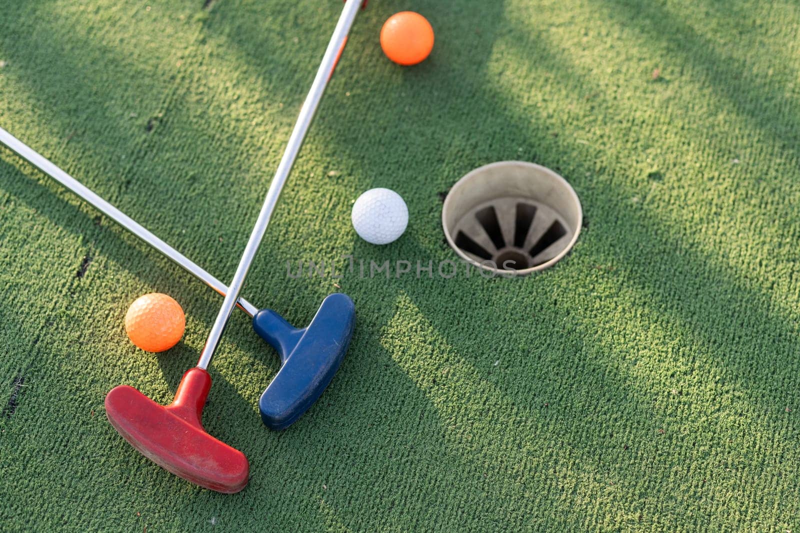 Golf ball and golf club on green in the evening golf course with sunshine . High quality photo