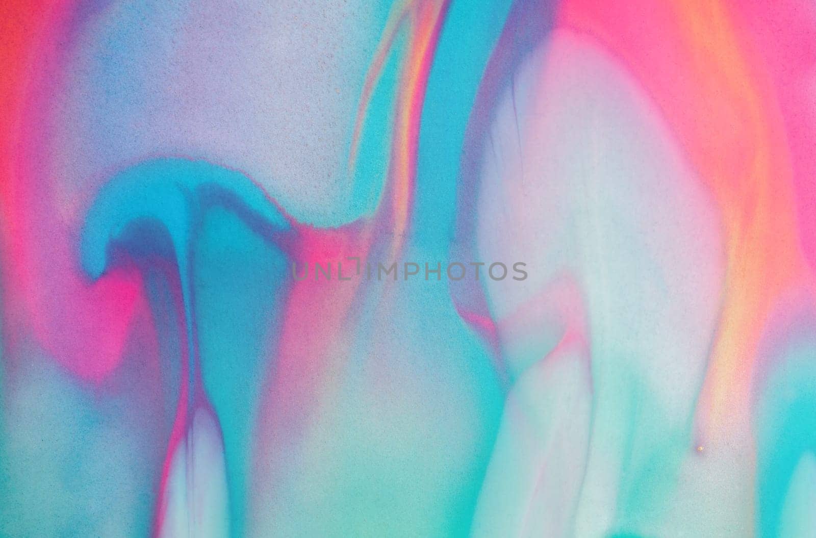 Swirls of vibrant blue, pink, and white merge fluidly, resembling an abstract wave under the soft, glowing light of late afternoon.