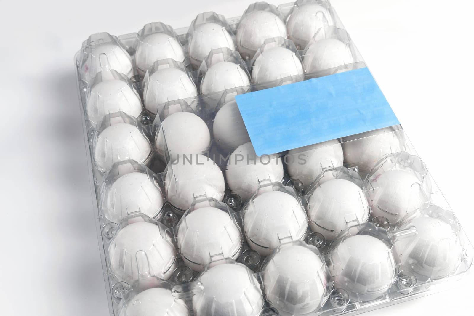 Raw white chicken eggs in tray on white background. Organic food from nature.