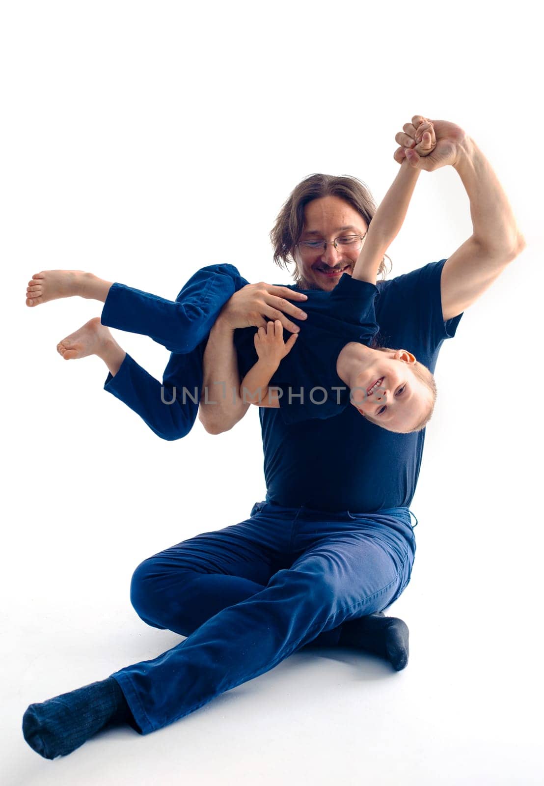 young handsome father with his son fooling around, lifestyle on white background. High quality photo