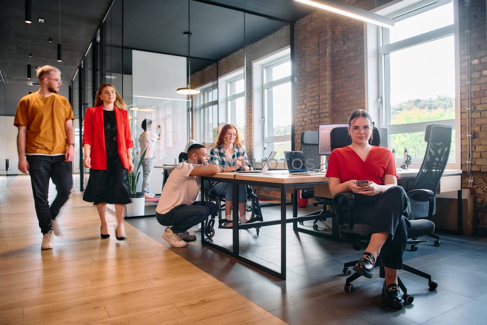 A diverse group of business professionals collaborates in a modern startup coworking center, utilizing a mix of paper-based and technological tools such as mobile phones and computers .