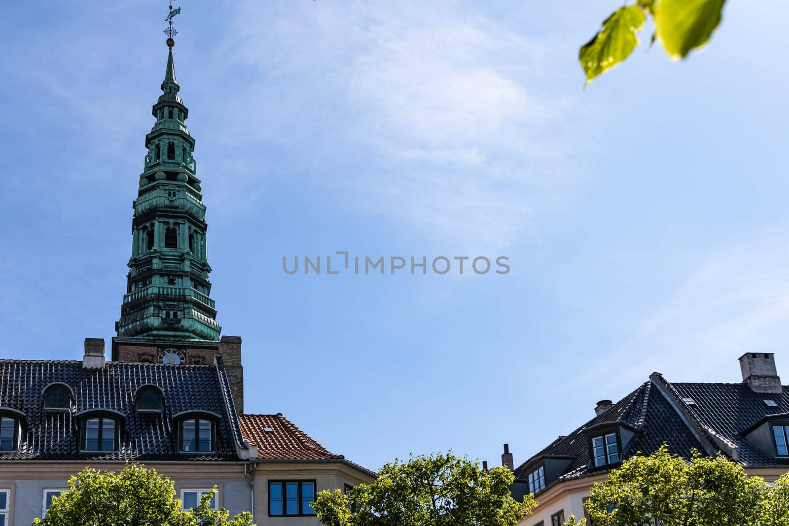 Downtown Copenhagen with old houses and church on a sunny day.