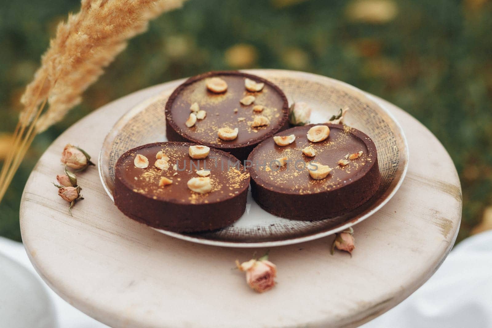 Three delectable chocolate desserts beautifully presented on a plate, adorned with delicate flowers.