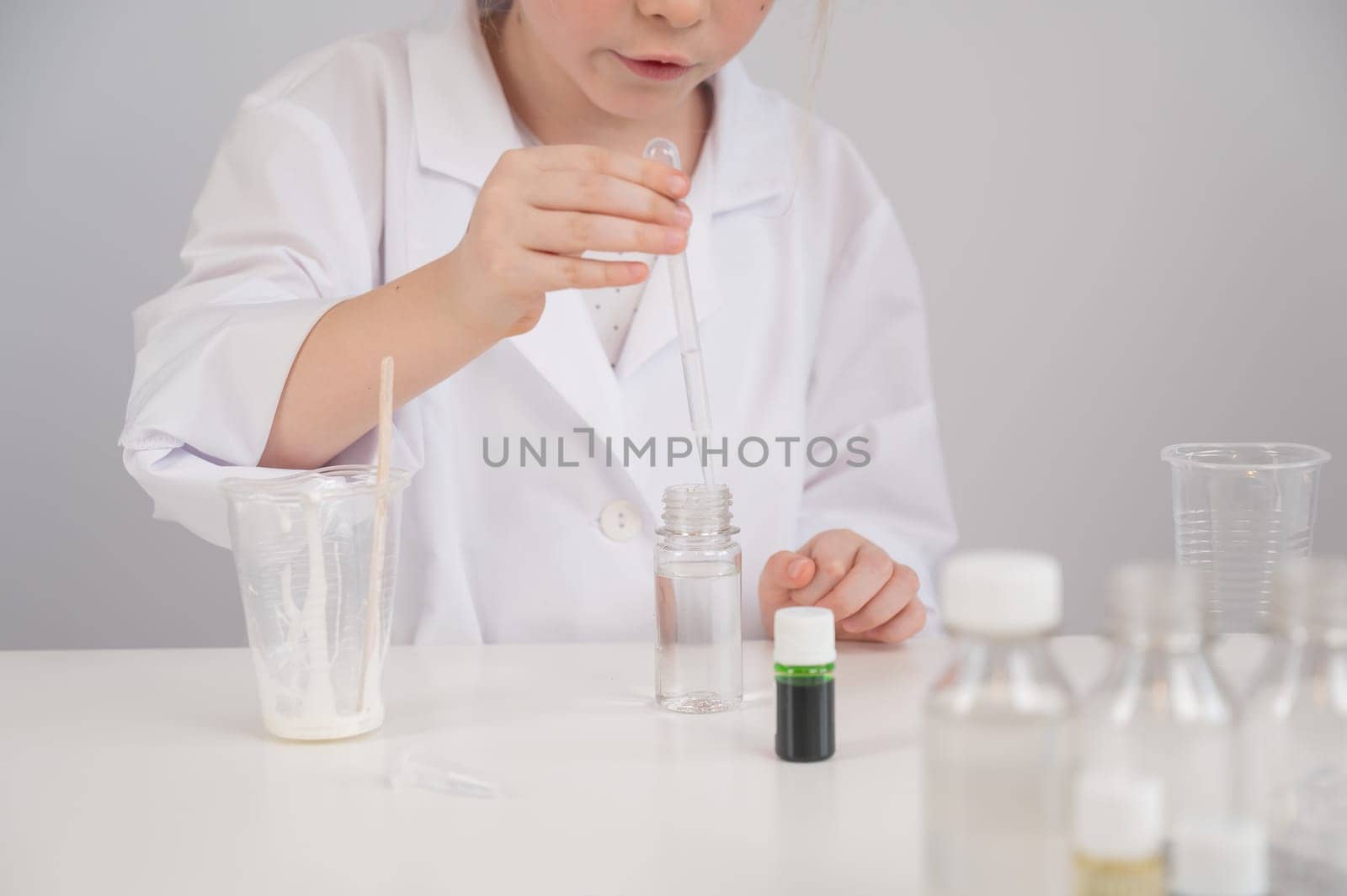 Caucasian girl doing chemical experiments on a white background