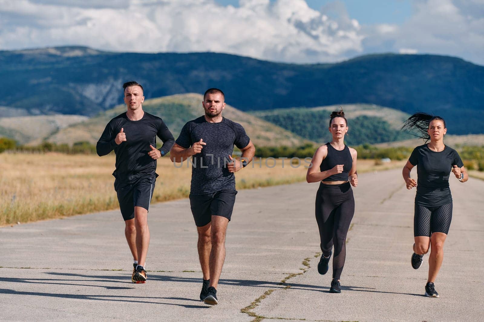 A professional athletic team as they train rigorously, running towards peak performance in preparation for an upcoming marathon.