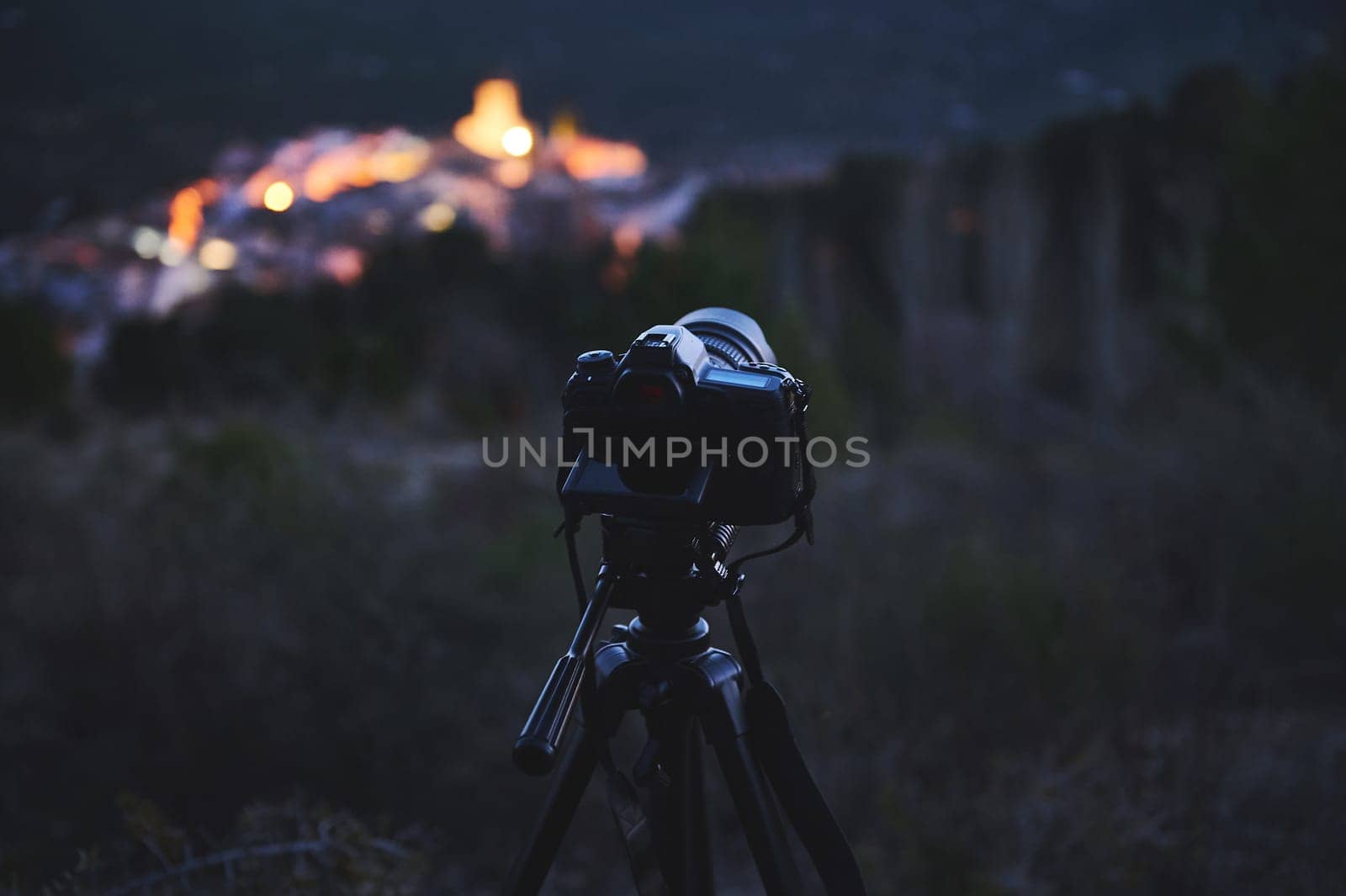 Digital camera placed on tripod, capturing the Andalusian medieval city of Quesada in mountains Sierra de Cazorla at dawn. Blurred mountains on background. Travel photography. World photography Day by artgf