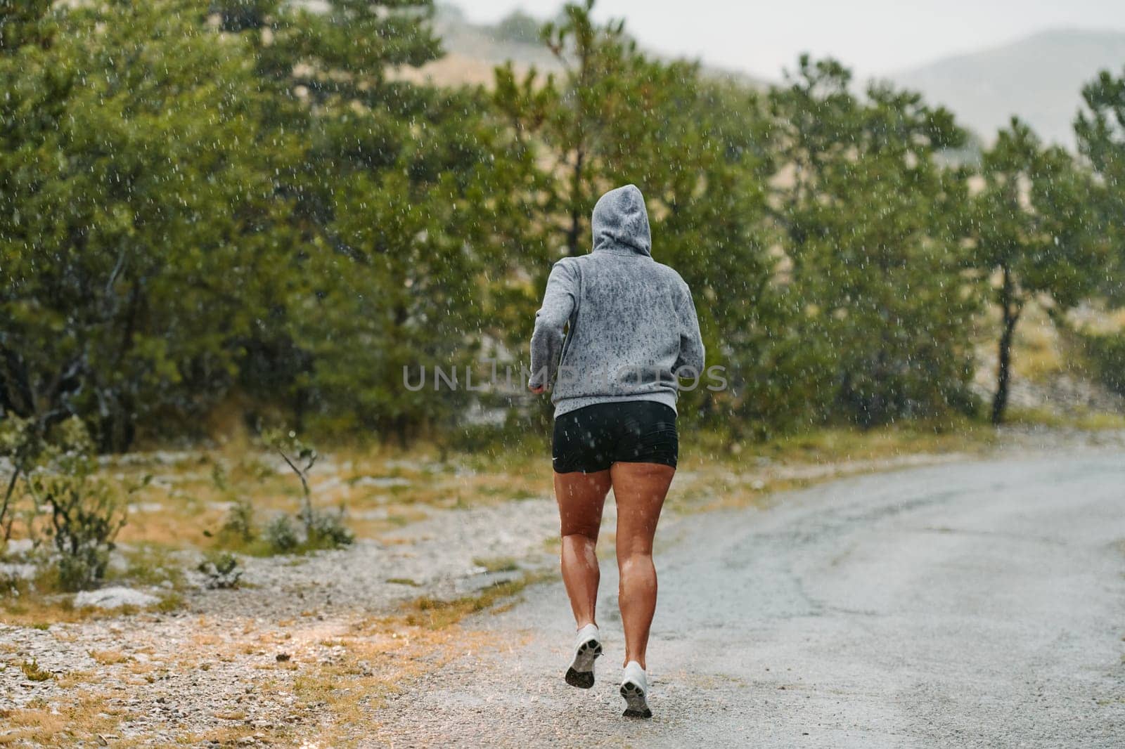 Rain or shine, a dedicated marathoner powers through her training run, her eyes set on the finish line.