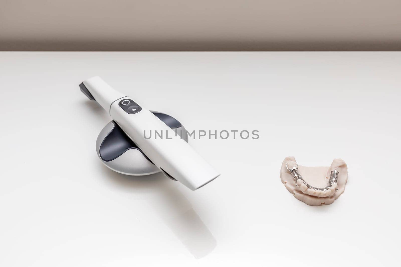 Bridge Printed By 3d Printer on Table. 3D Intraoral Teeth Scanner For Imaging Tooth and Metal Frame Lower Partial Denture, Cobalt Chrome Dental Plate. No People. Dental Equipment, Device, Dentistry