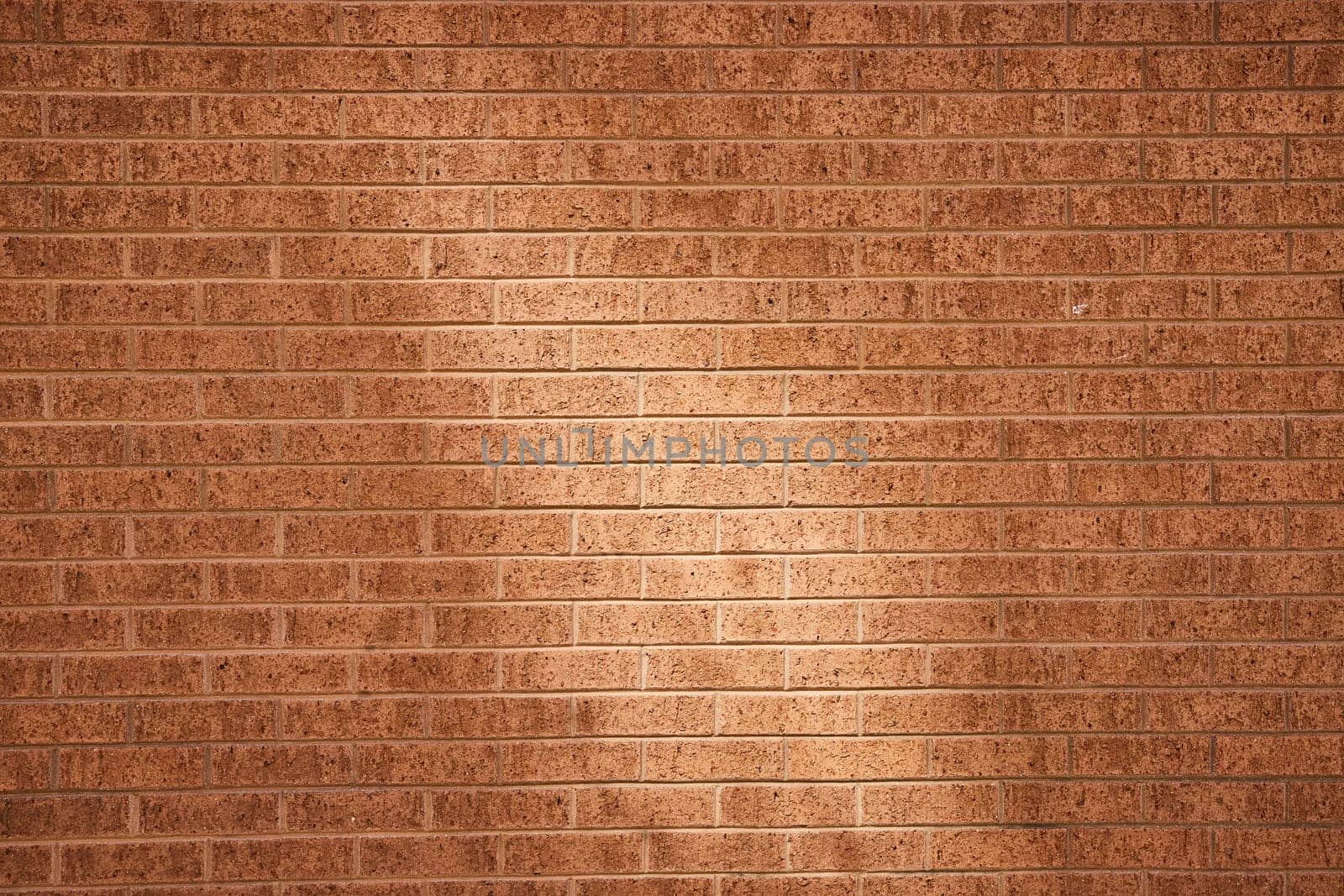Warm, textured brick wall in downtown Fort Wayne, Indiana, perfect for architecture and design projects.