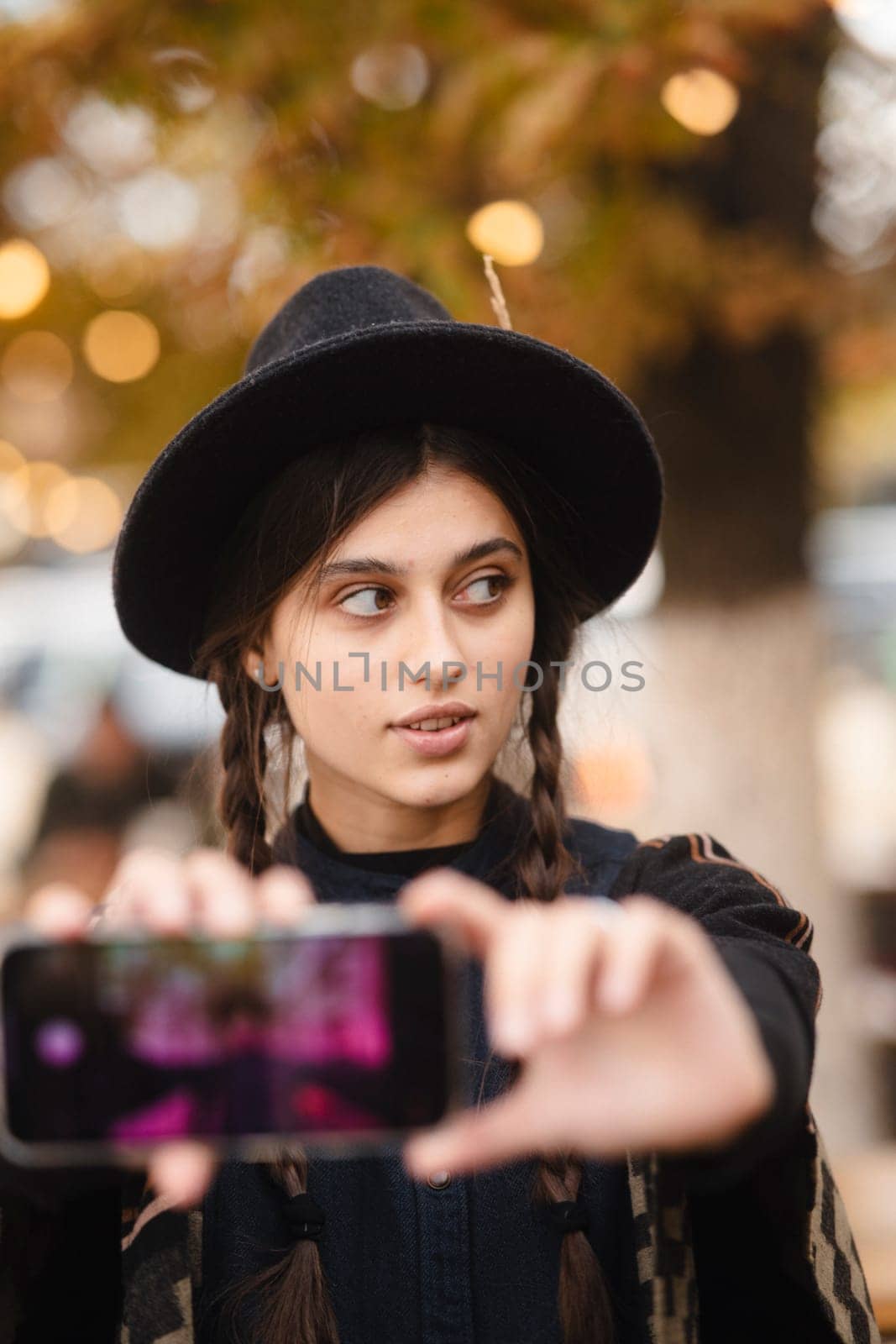 An elegant and stylish lady, accessorized with a black hat and a braided hairstyle. High quality photo