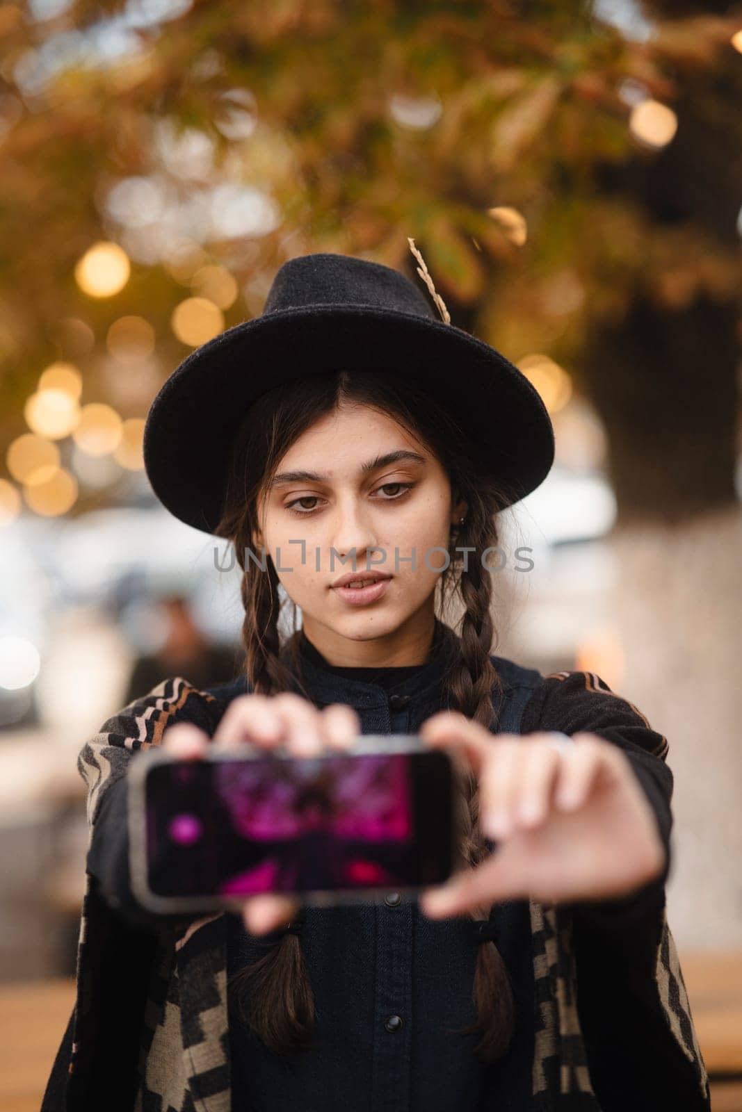 A chic, fashion-forward girl with a black hat and a braided hair look. High quality photo