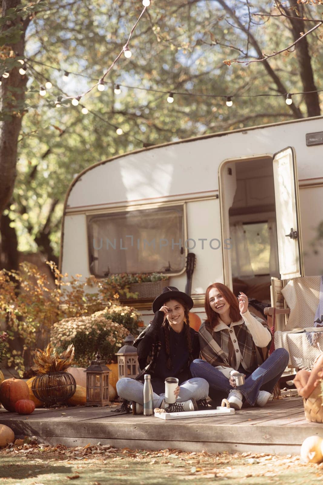 A pair of trendy gals don boho-chic attire against the trailer backdrop. High quality photo