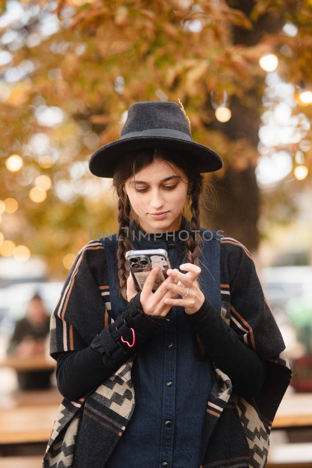 A vibrant, stylish girl in a black hat, sporting a braided hairstyle. High quality photo