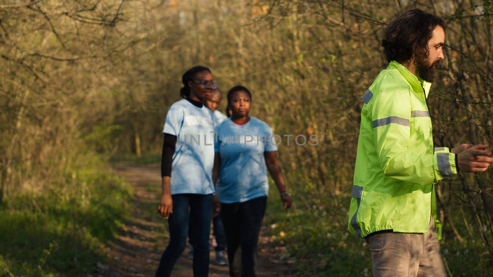 Captain of the search party directs his team through the woods to collect details during ongoing hunt for a missing person. Voices calling out for an individual's name, civil missing into the wild. Camera A.