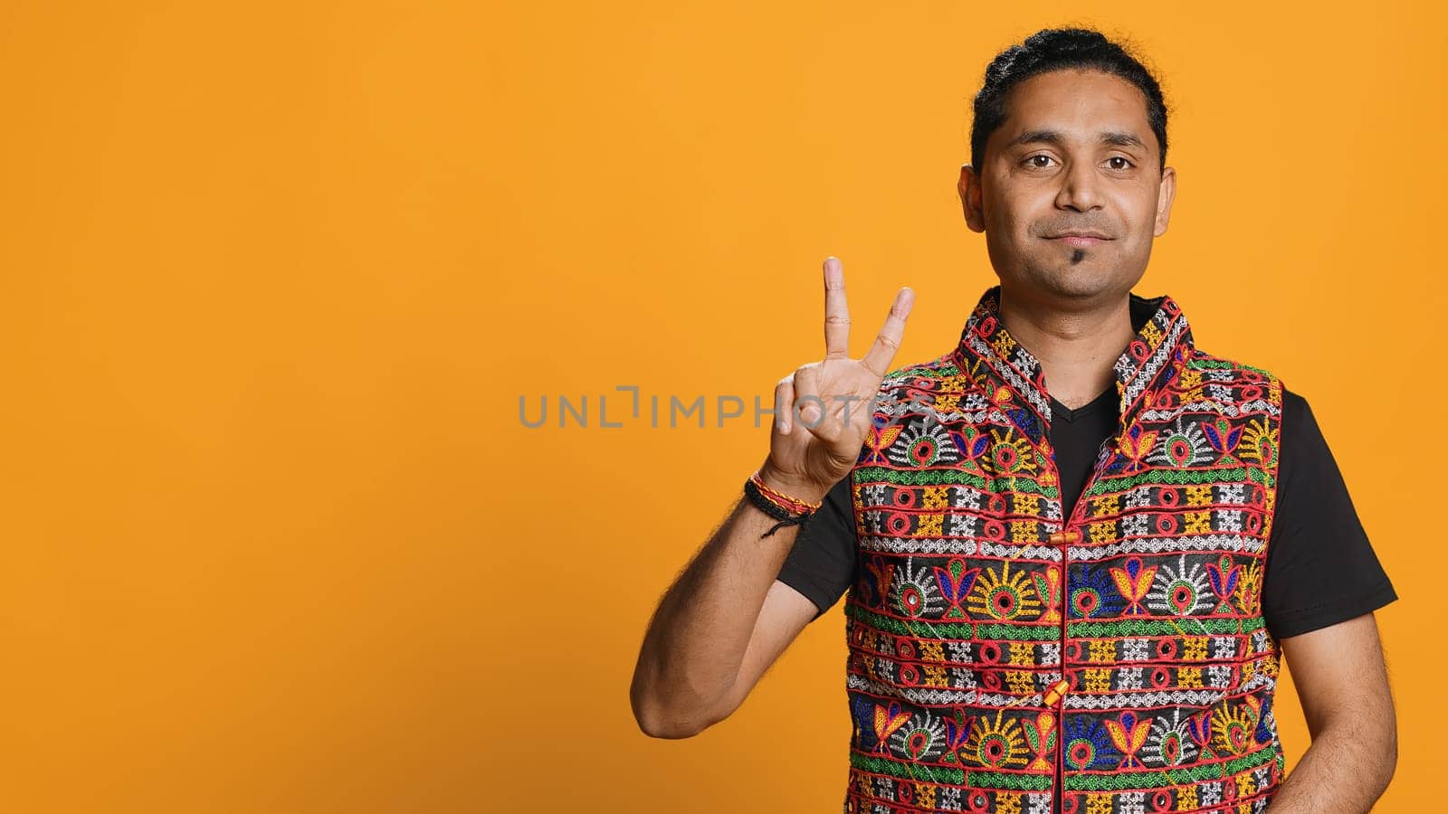 Portrait of man crossing fingers and doing victory sign, studio background by DCStudio