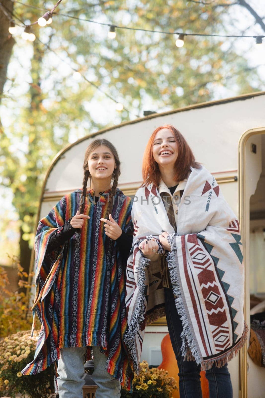 Two hip girls showcase their hippie-inspired outfits against the trailer setting. High quality photo