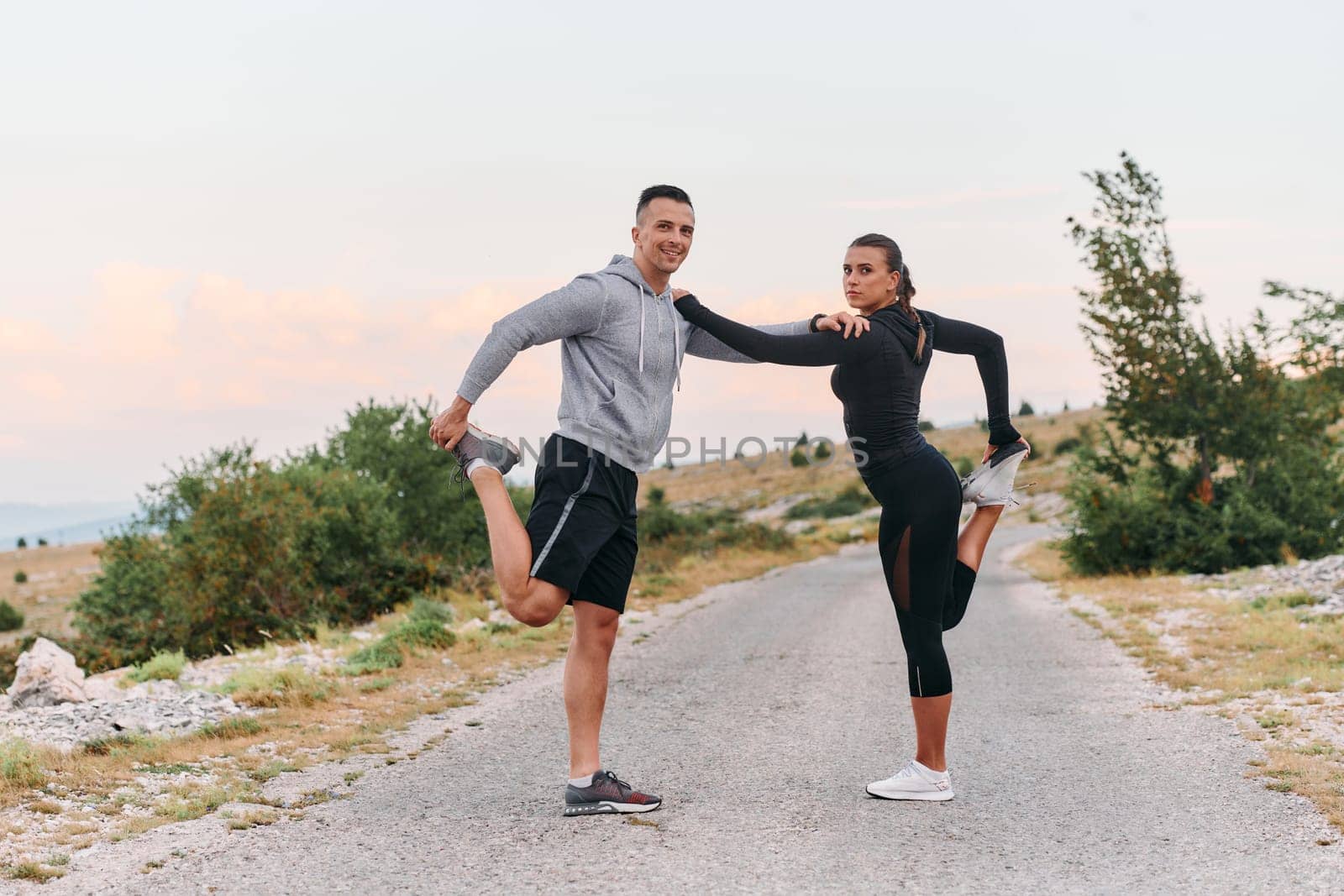 A Romantic Couple Stretching Down After a Run by dotshock