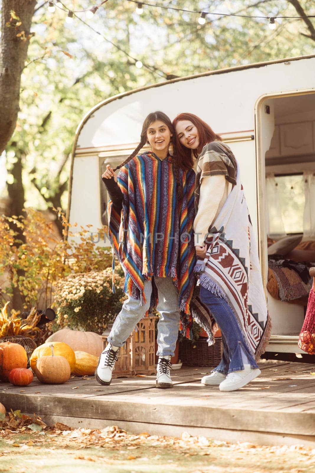 Two hip girls showcase their hippie-inspired outfits against the trailer setting. High quality photo