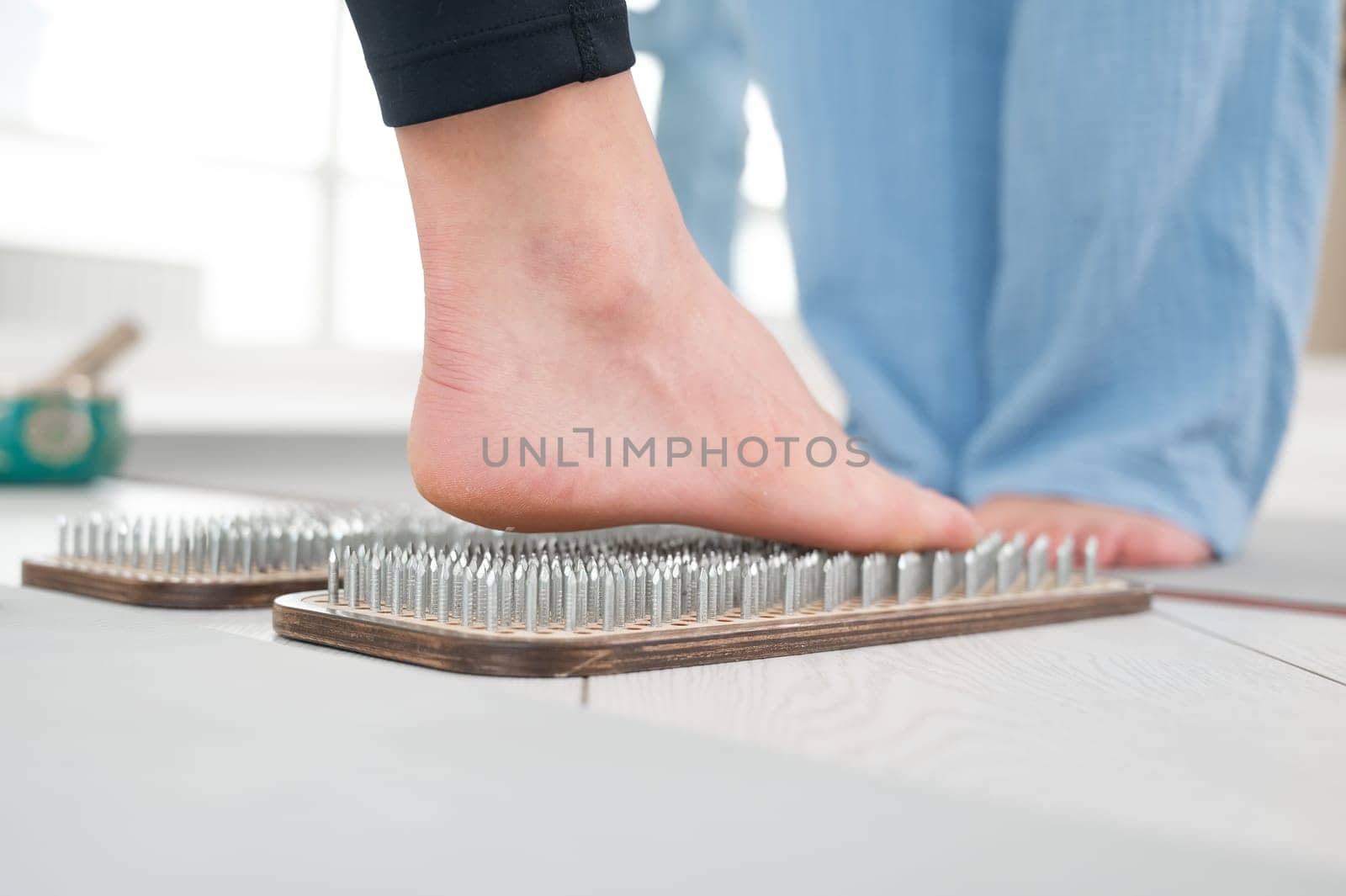 Caucasian woman stands on sadhu boards with therapist support. by mrwed54