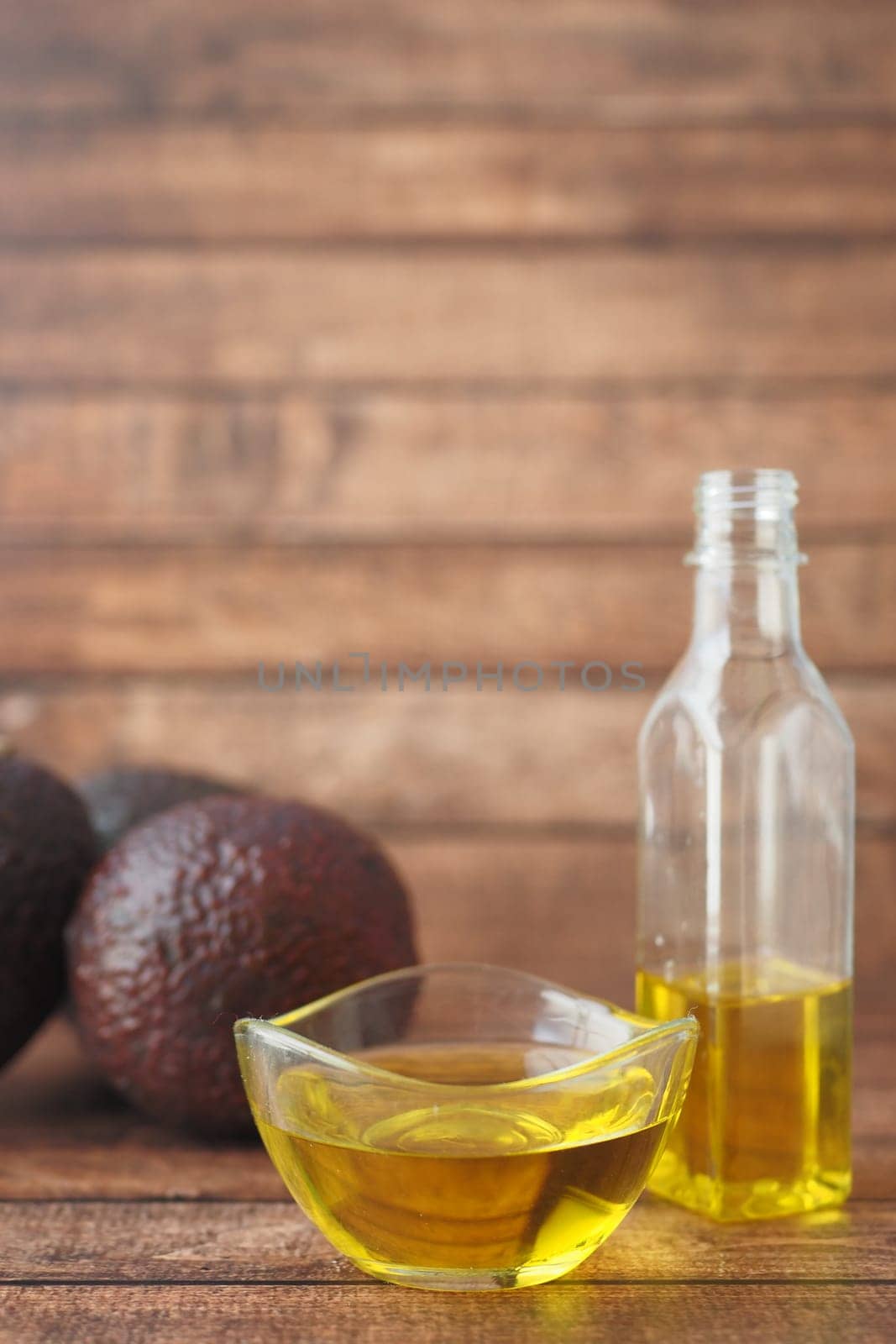 oil and slice of avocado on wooden table by towfiq007