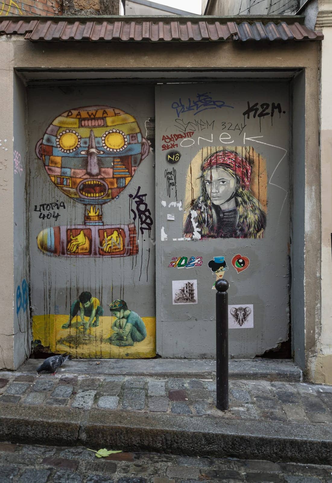 France, Paris - Jan 03, 2024 - A artistic metal doorway stickers and graffiti on Montmartre Street. Street art in Paris, Urban intervention art, Paris wall art, Space for text, selective focus.