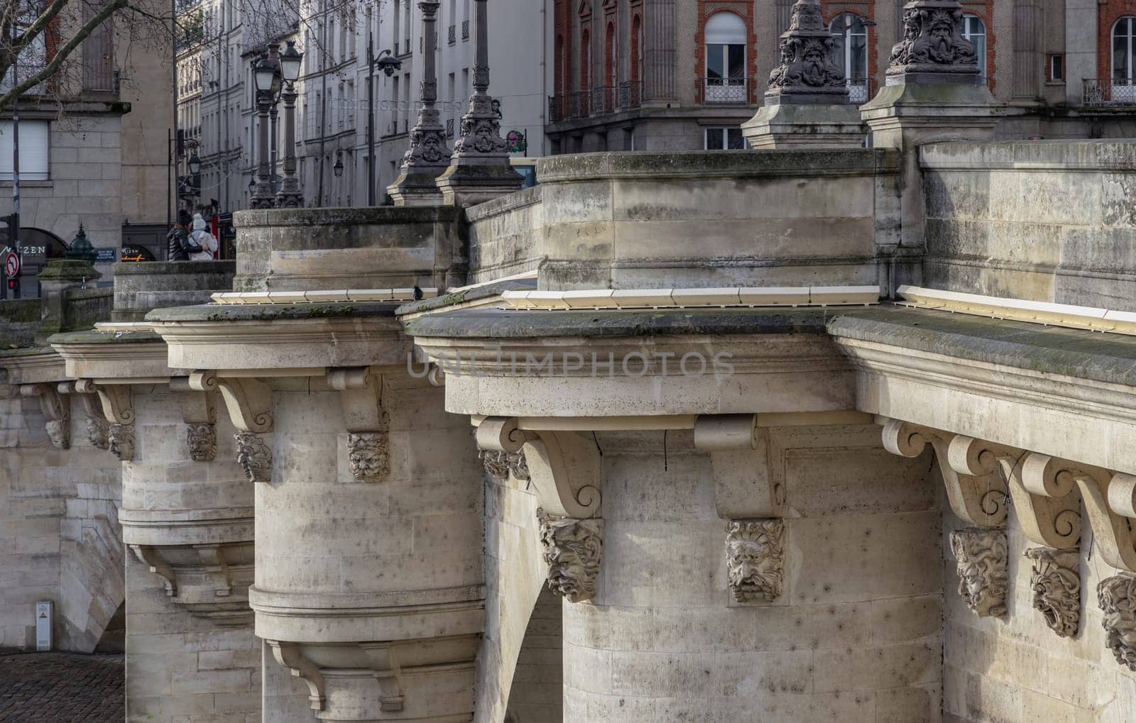 France, Paris - Jan 03, 2024 - Detail of Round bastions which give it the look of a castle and ornate gargoyles are humorous, grotesque figures of dentists, pickpockets and loiterers on the Pont Neuf bridge. Copy space, Selective focus.