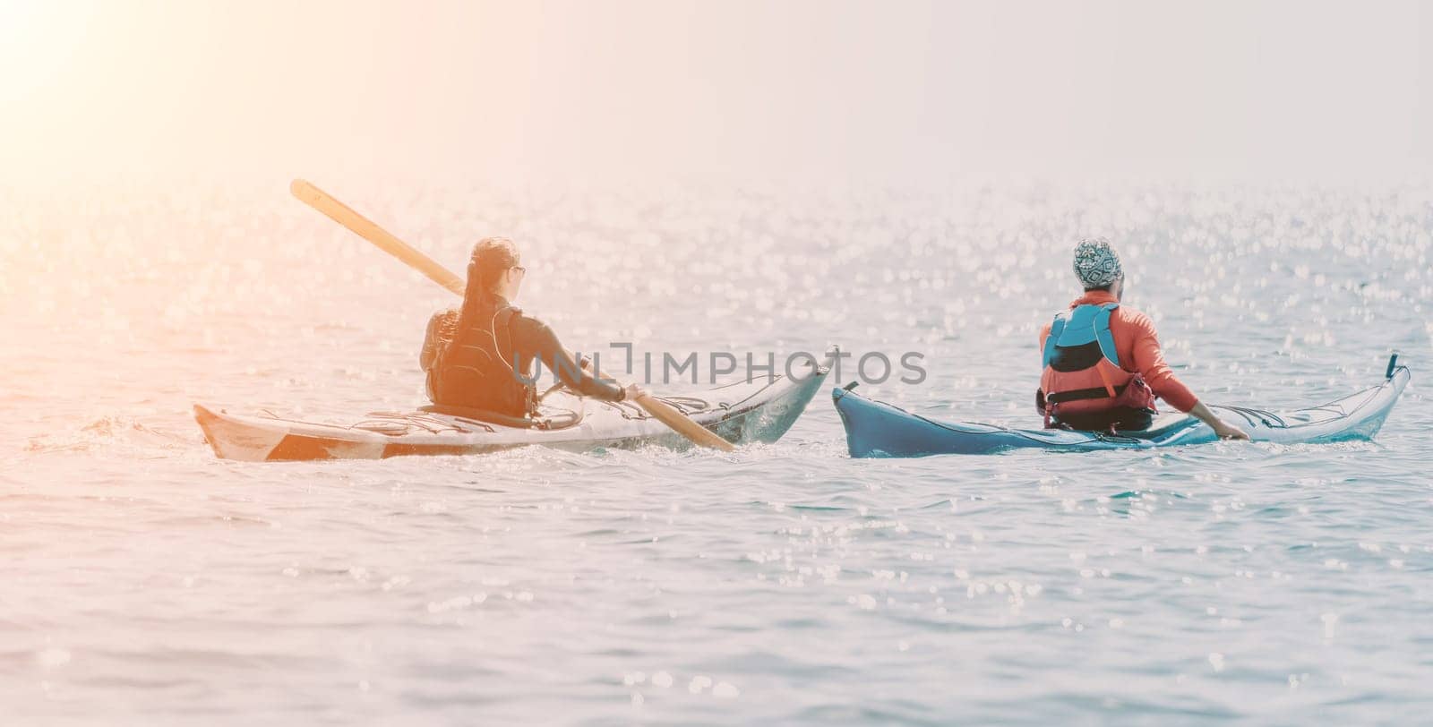 Man woman sea kayak. Happy free man and woman in kayak on ocean, paddling with wooden oar. Calm sea water and horizon in background. Active lifestyle at sea. Summer vacation. by panophotograph