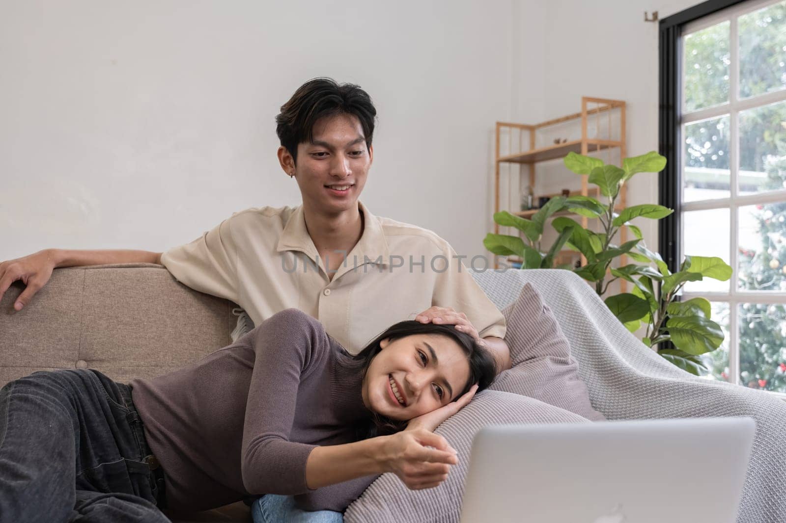 Young Asian couple in love Sitting and relaxing together in the living room happily. Couple making romantic love in the living room.