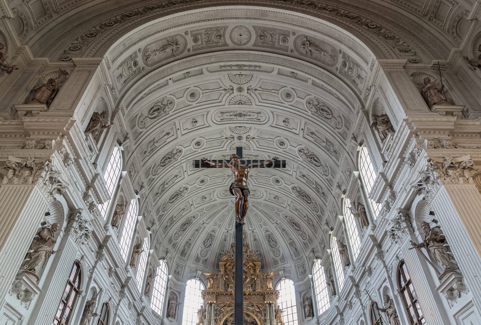 Munich, Germany - Dec 21, 2023 - Jesus hanging on the cross, Crucifix in the interior of St. Michael's Church (Michaelskirche Jesuit church) in Munich pedestrian zone. It is the largest Renaissance church north of the Alps. Space for text, Selective focus.