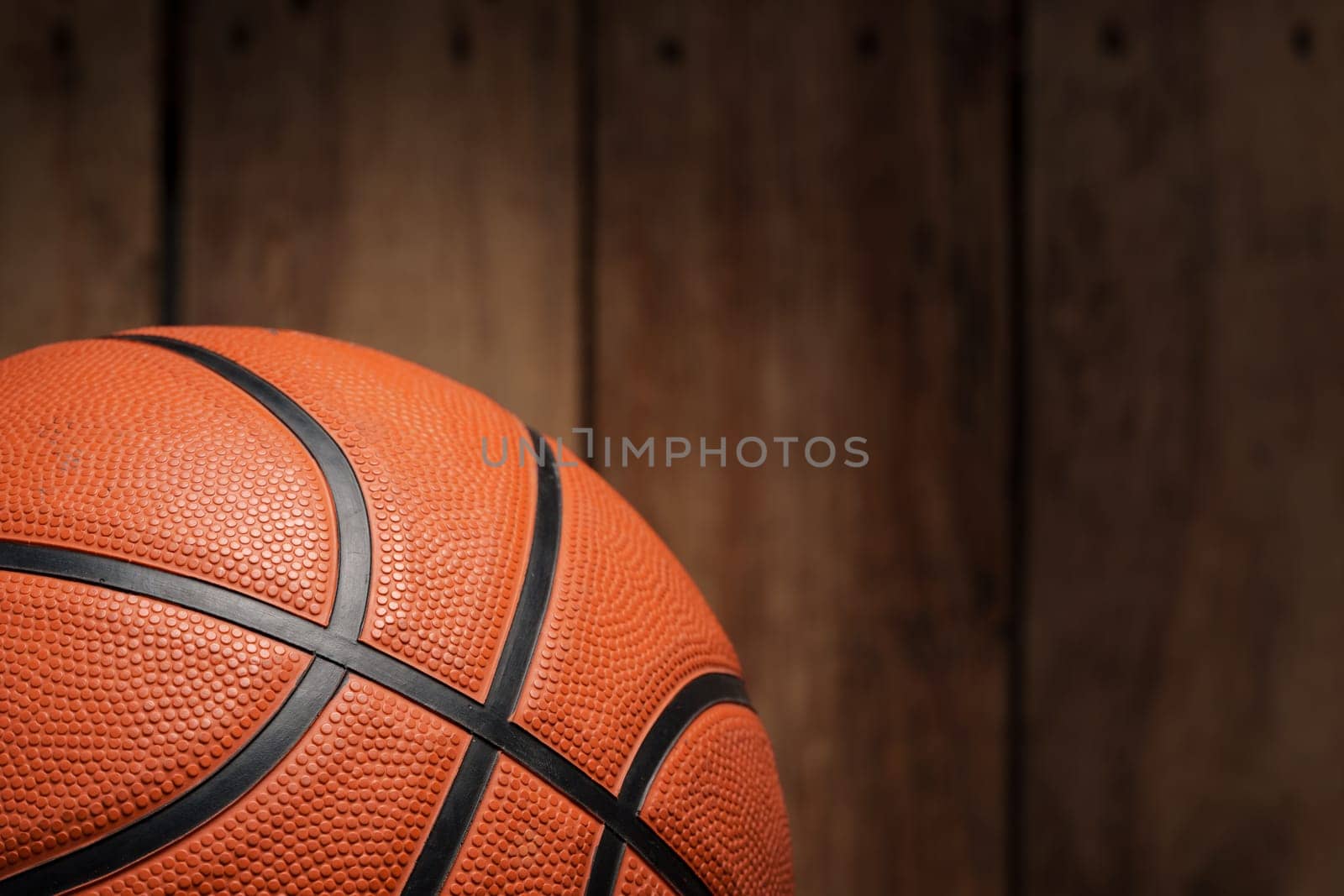 Basketball ball lying on a wooden floor close up