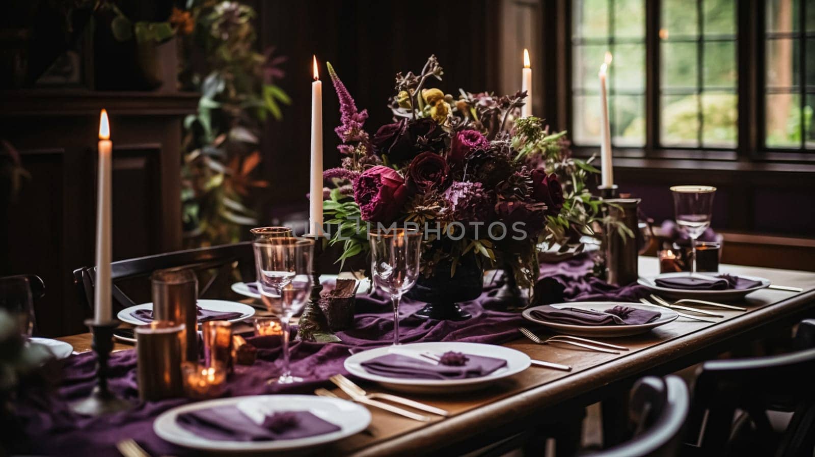 Dinner table setting in the warm glow of candlelight, tablescape featuring floral centerpiece, elegant burgundy glassware, and luxurious gold cutlery by Anneleven