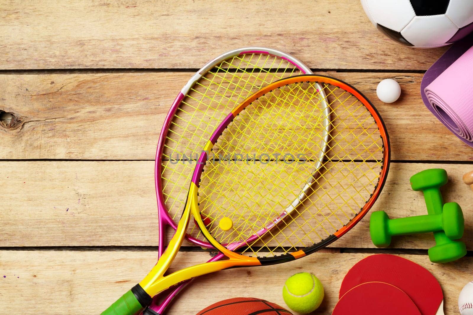Different sports equipment on wooden background top view photo
