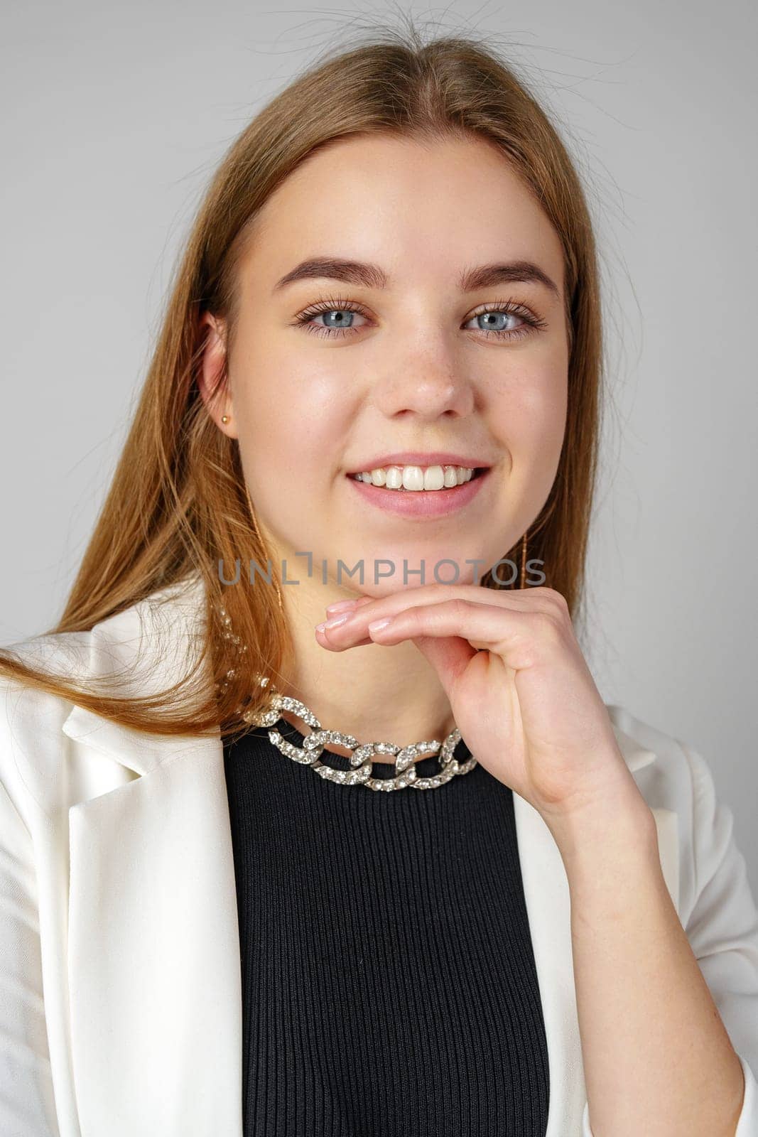 Woman in Black Top and White Jacket Posing in Studio close up