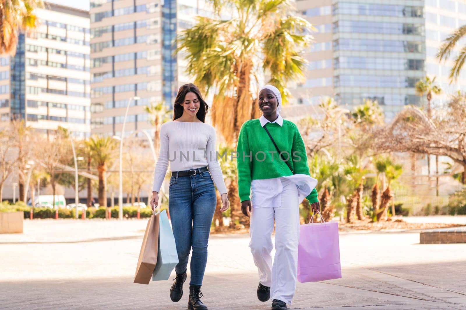 two female friends walking in a shopping area by raulmelldo