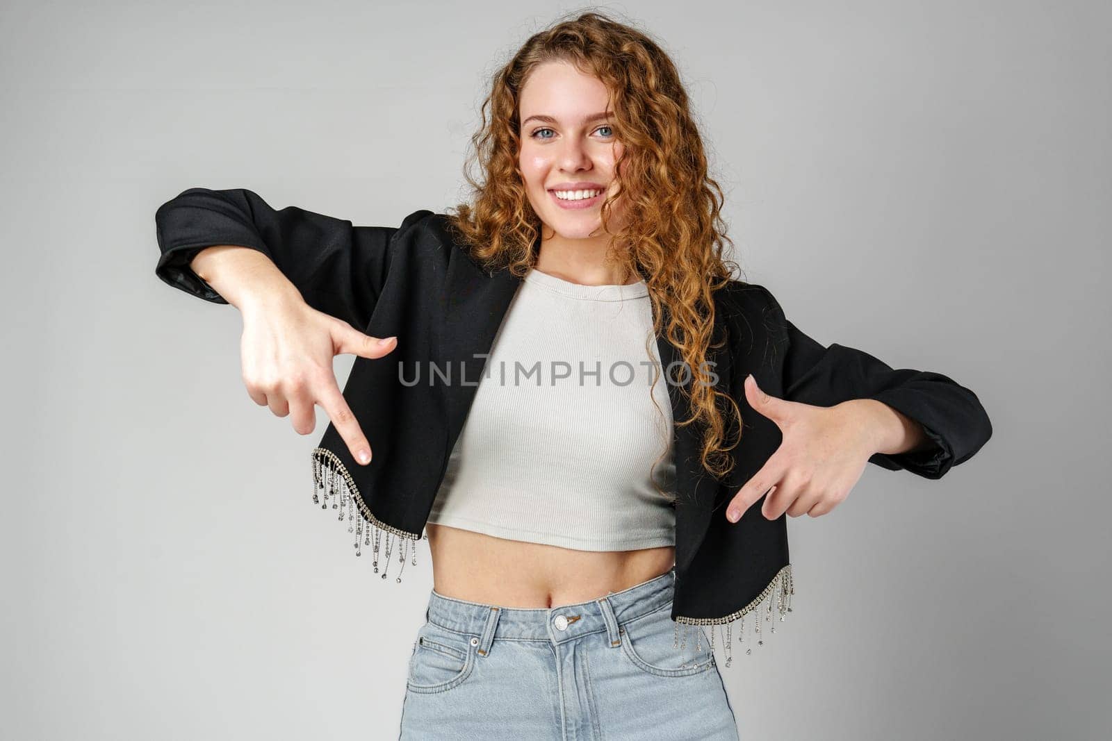 Woman in Crop Top and Jeans Pointing Down Copy Space
