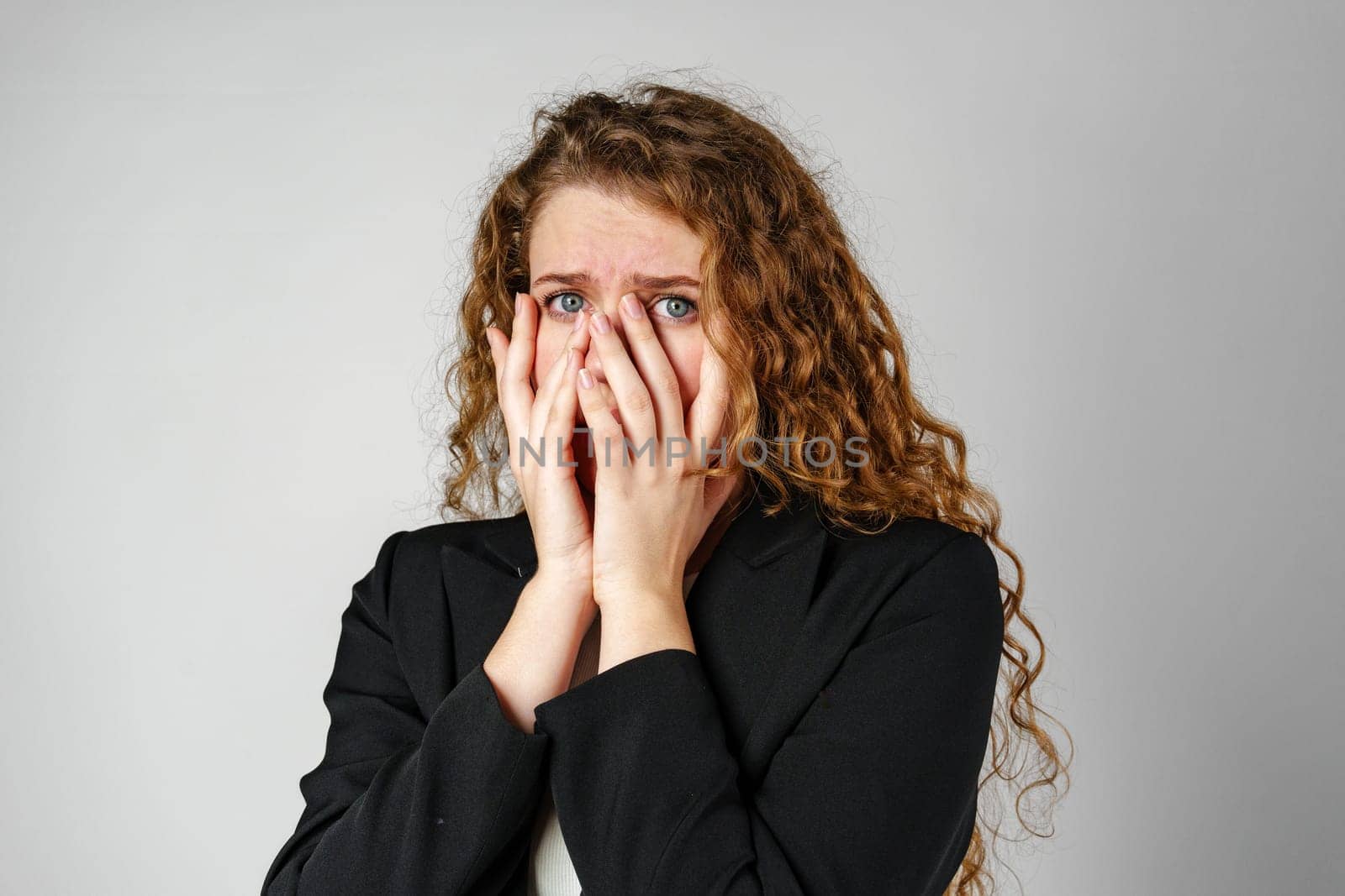 Young Woman Covering Face With Hands in Studio by Fabrikasimf